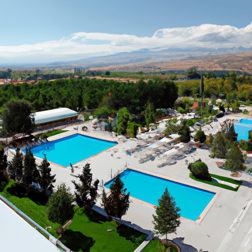 A panoramic view of a luxury hotel in Erzurum with a large outdoor pool surrounded by lush greenery.