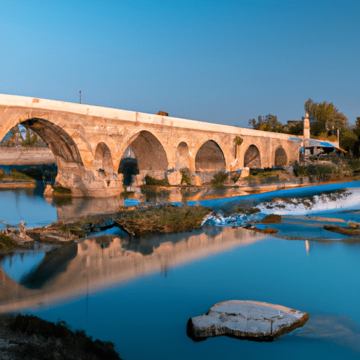 1. A panoramic view of the ancient Roman stone bridge, Taskopru, with the cityscape of Adana in the background.