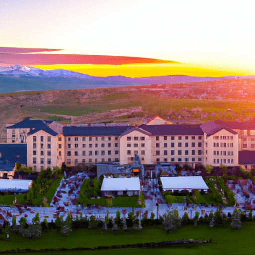 1. An aerial shot of a grand hotel in Erzurum, beautifully illuminated against the setting sun, with an outdoor wedding setup.